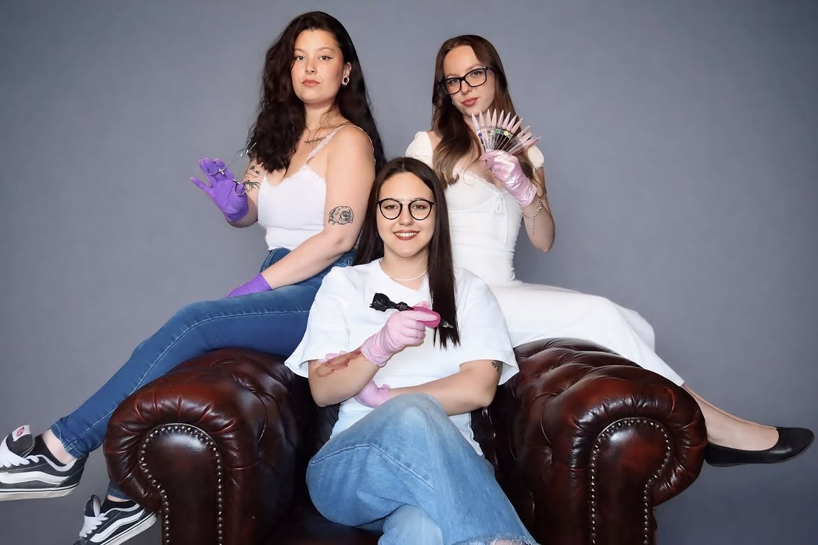 Jade, Simone et Axelle, l'équipe de Coco Tattoo GVA, sur un canapé Chesterfield